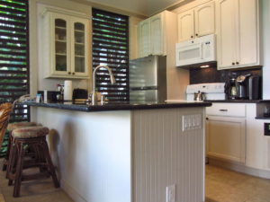 View of kitchen showing peninsula with countertop overhang making a bar top for short bar stools.